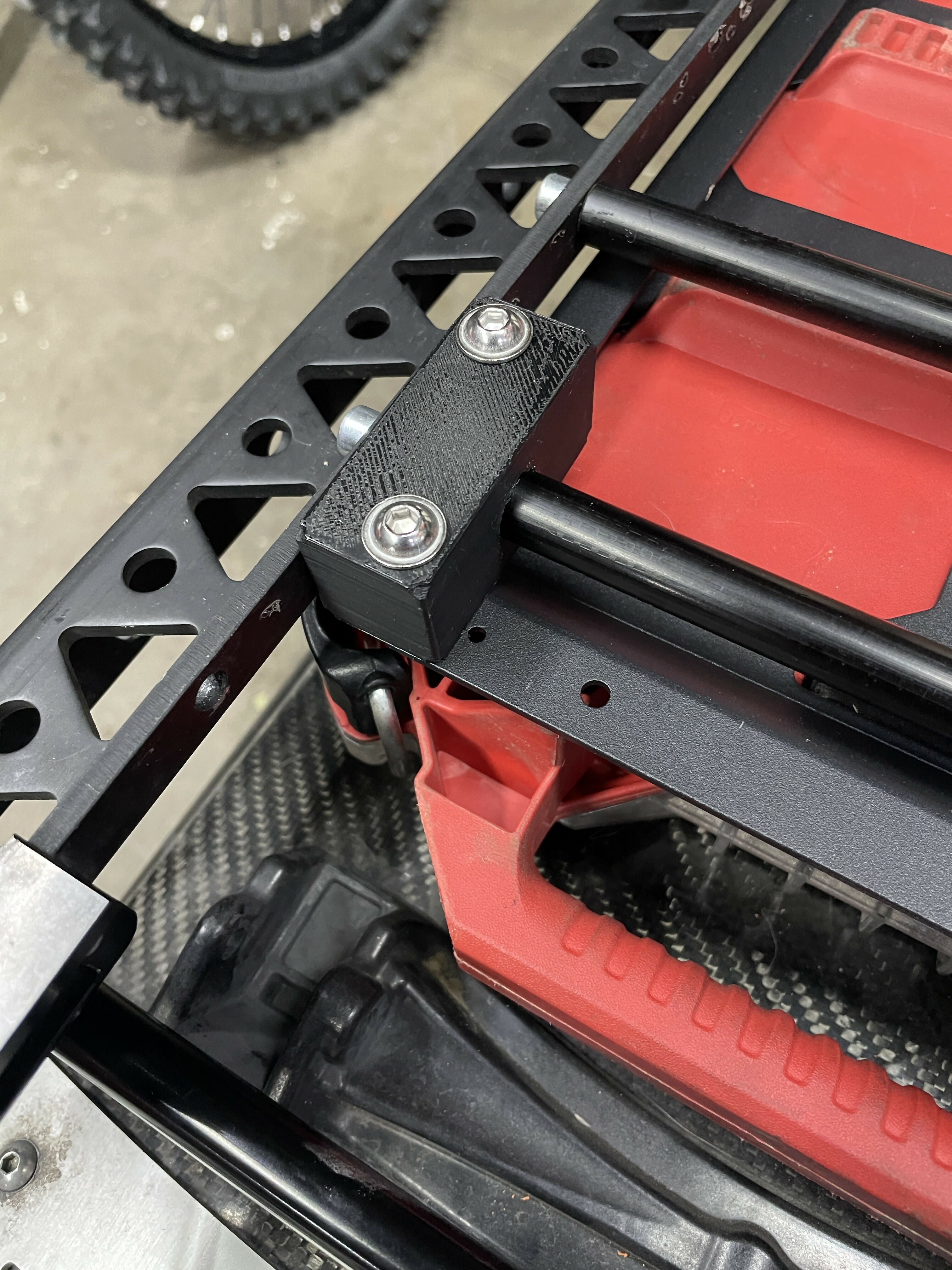 Close-up of a red and black mechanical component with metal brackets.