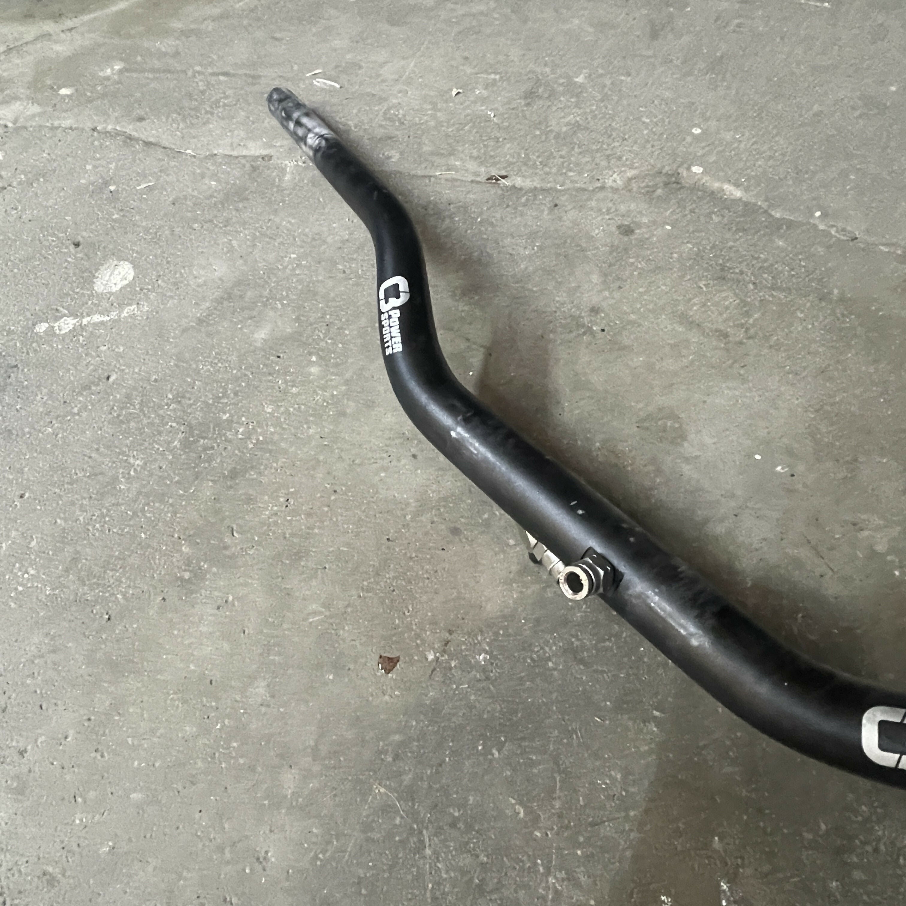 Black motorcycle handlebar on a concrete floor
