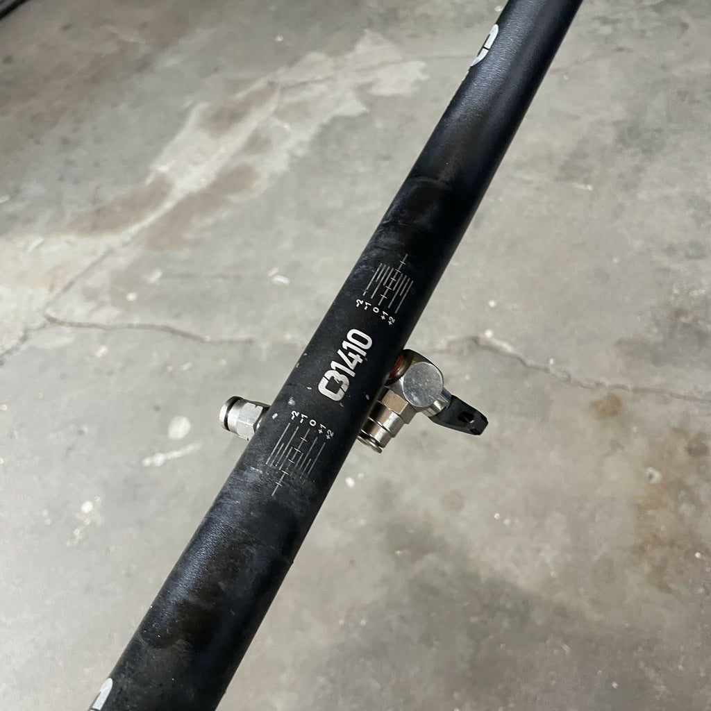 Black bicycle handlebar with 'G3410' branding on a concrete floor.